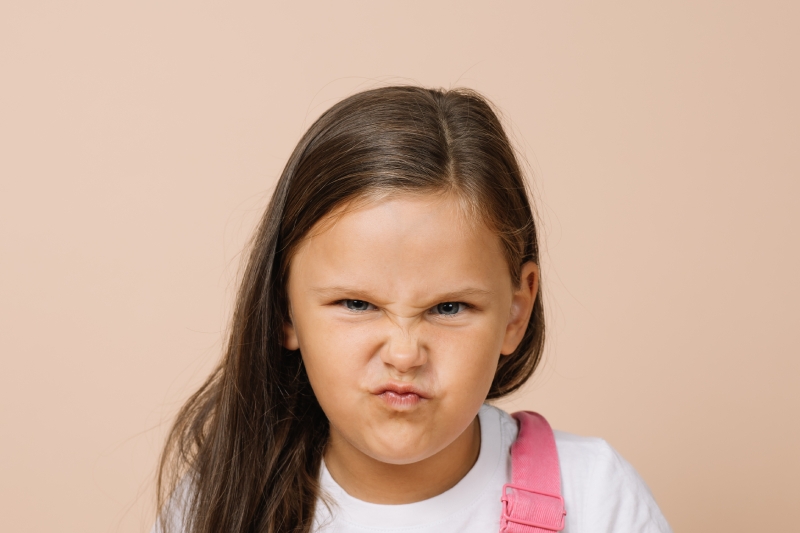 A child making a grimacing, scowling face